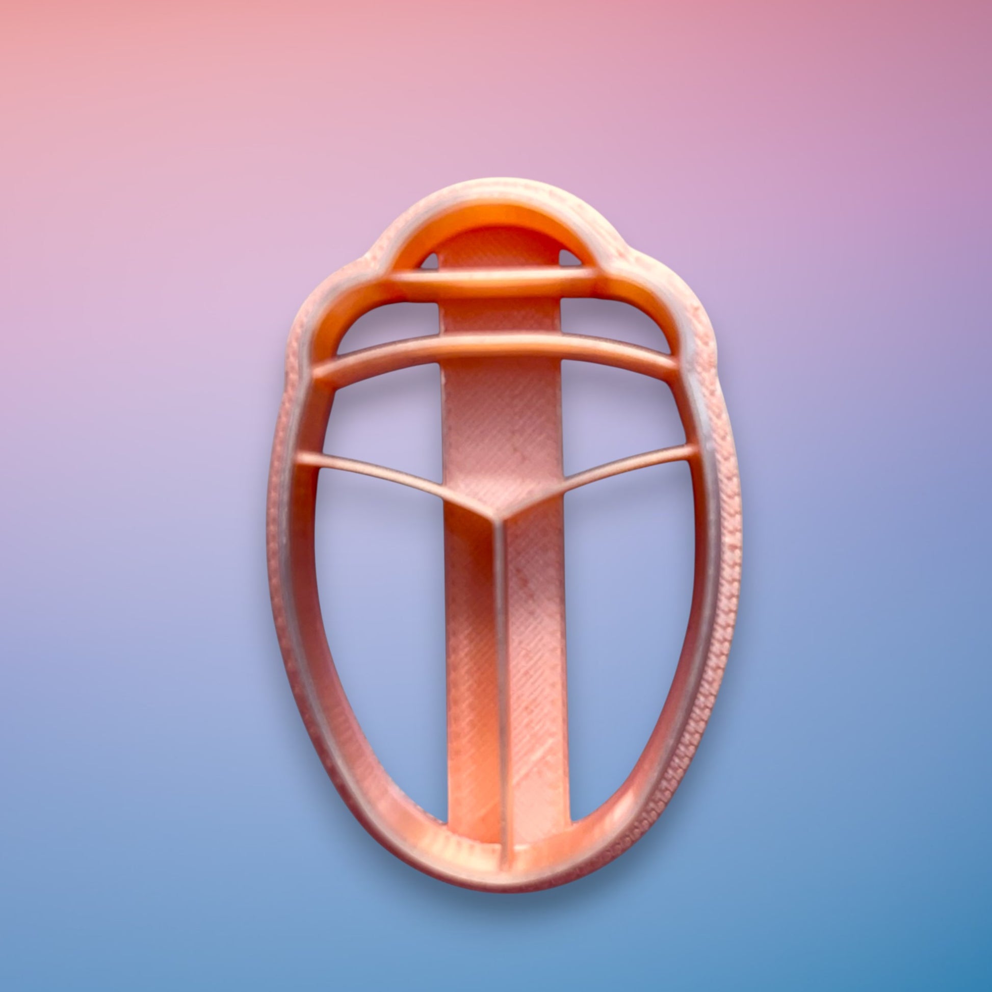 Beetle polymer clay cutter with smooth rounded body and segmented detail on white background.