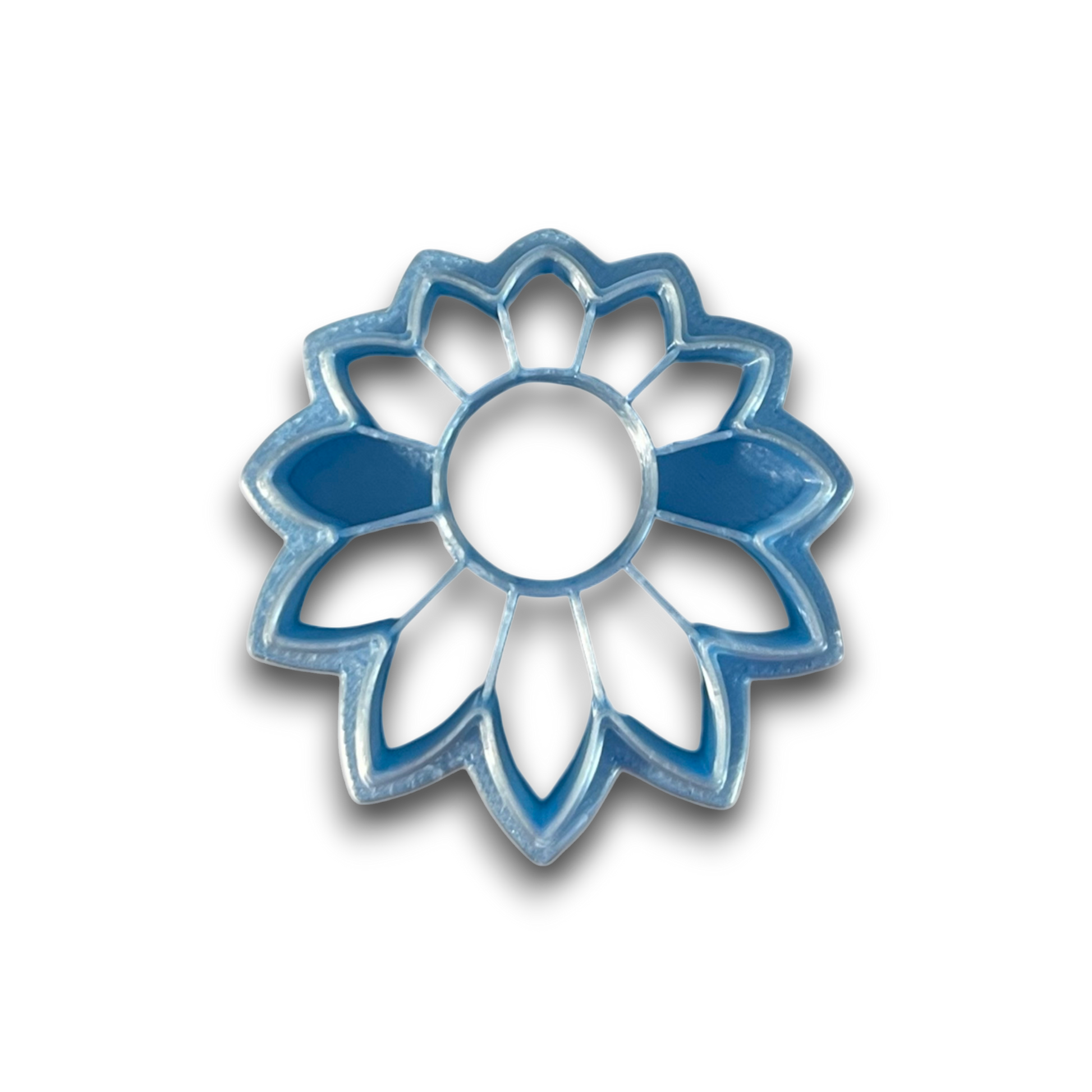 Boho Daisy polymer clay cutter with rounded center and elongated sunburst petals on white background.