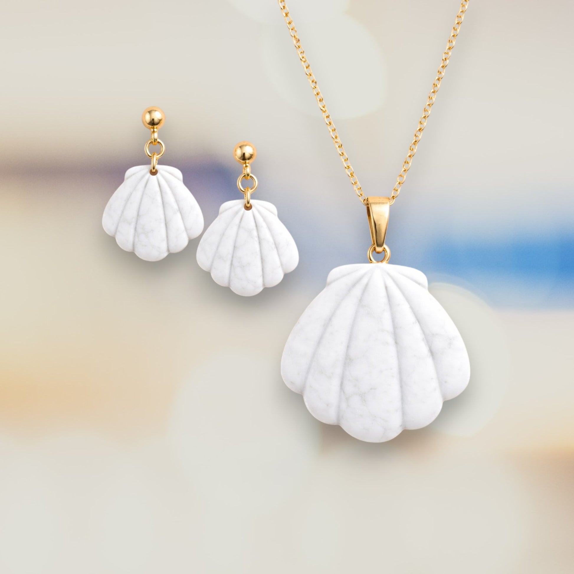 White scalloped shell polymer clay earrings and matching pendant with smooth matte finish, inspired by seashell shapes.